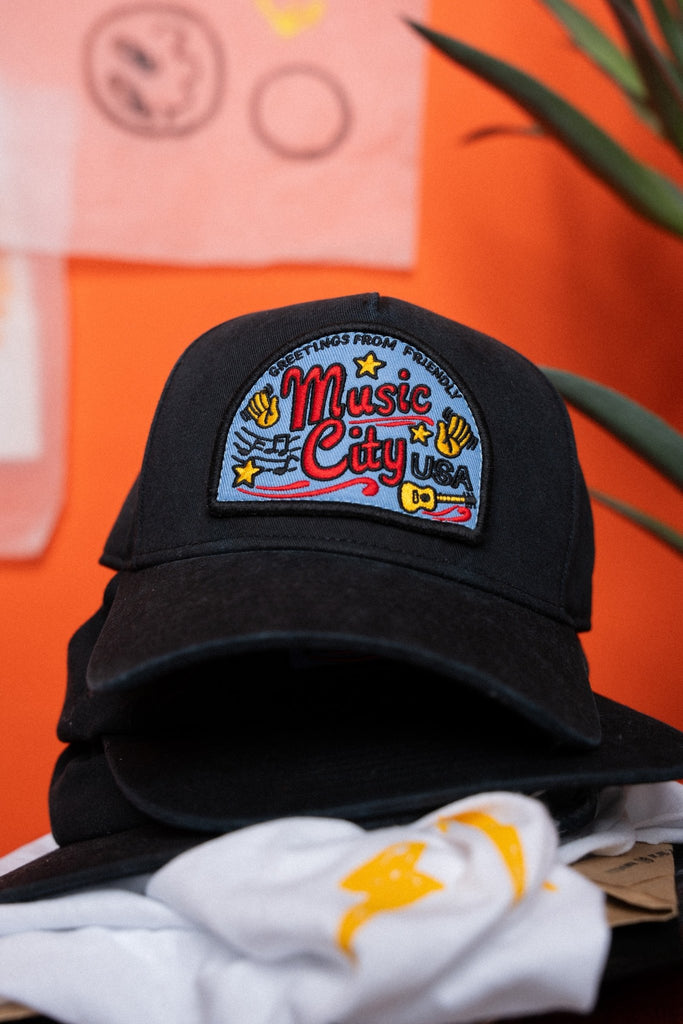 Black cap with 'Music City USA' patch on an orange background