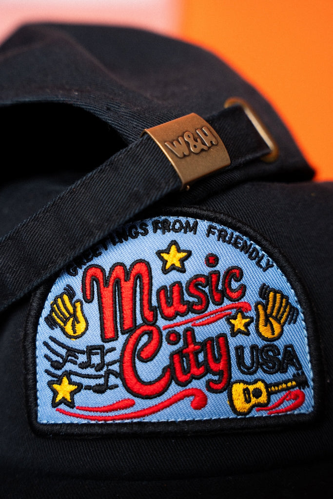 Black cap with 'Music City USA' patch on an orange background