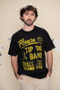 Man wearing a black t-shirt with yellow text that says "please tip the band" on a beige wall background